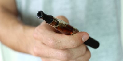 man holding a vape that takes CBD dabs man holding a vape that takes CBD dabs