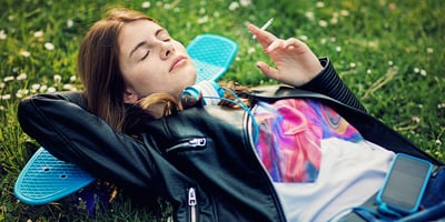 Teenage girl is lying down and enjoying a smoke session Teenage girl is lying down and enjoying a smoke session