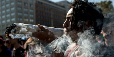 A demonstrator with a high weed tolerance smokes a huge joint during the "Cultivate Your Right" rally demanding the legalization of marijuana, in Santiago, on May 05, 2018. A demonstrator with a high weed tolerance smokes a huge joint during the "Cultivate Your Right" rally demanding the legalization of marijuana, in Santiago, on May 05, 2018.